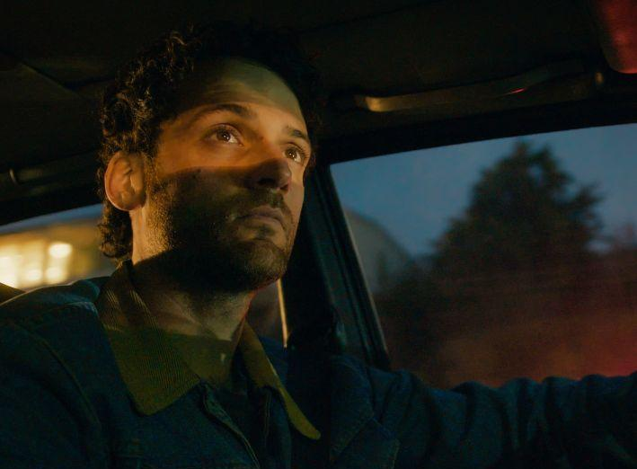 Man sitting quietly driving home after a long day, representing the exhaustion that can lead men to pull away.