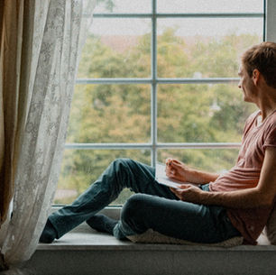 man sitting alone window natural light