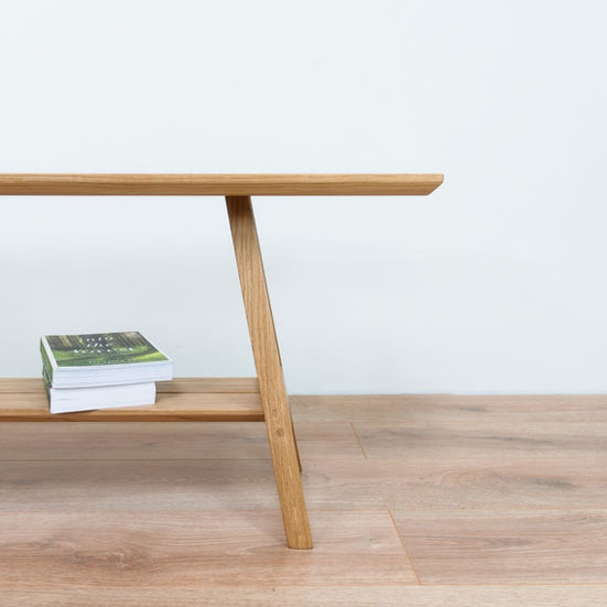 a wooden bench with a stack of books on it