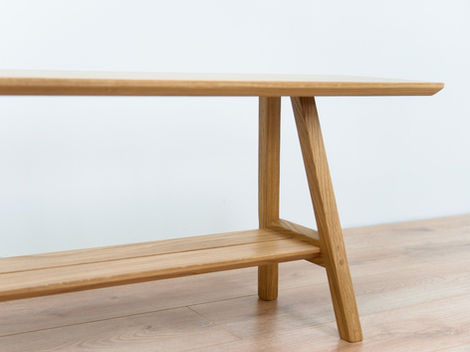 a wooden bench with a shelf underneath it