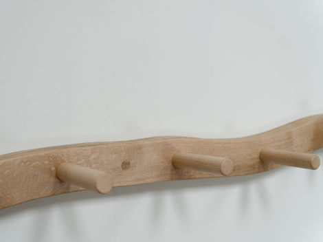 a wooden coat hook against a white wall