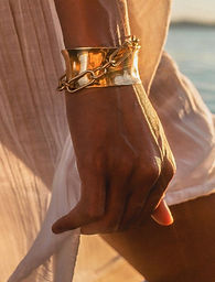 model draagt rede armband in goud van world's finest zomercollectie2026