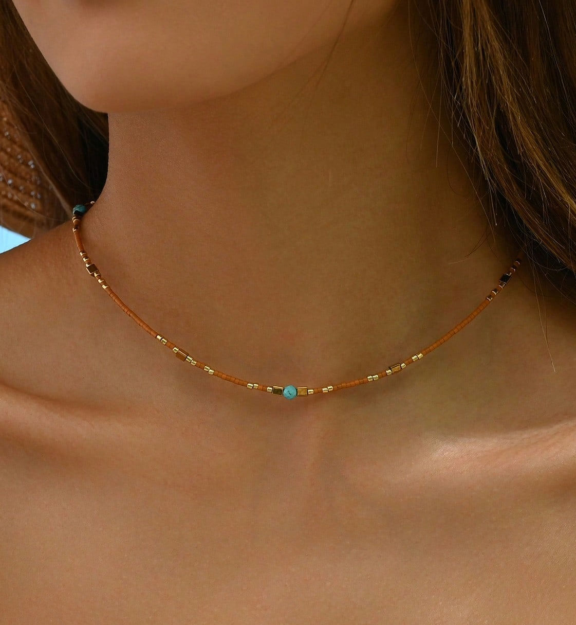 model draagt ketting met gouden en gekleurde kralen van world's finest modelfoto