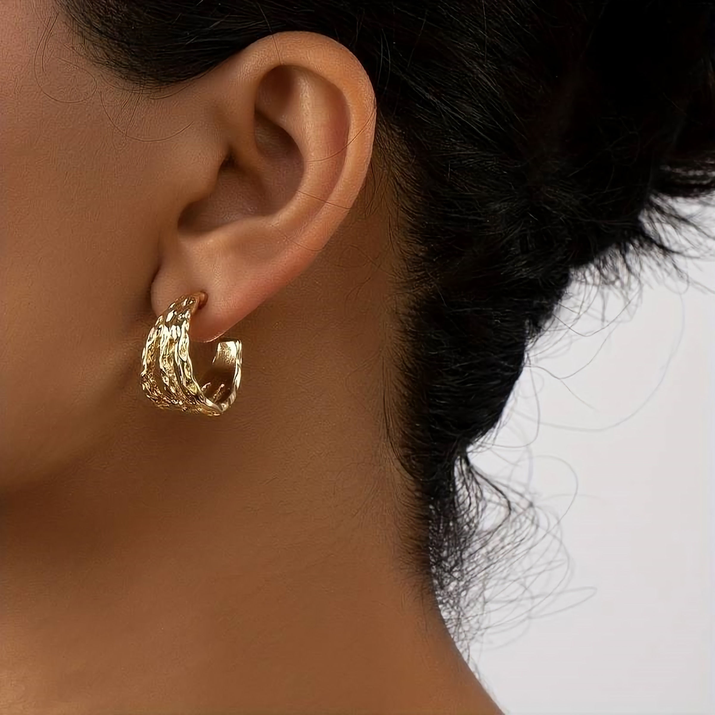 model draagt classic style kleine oorringen in goud