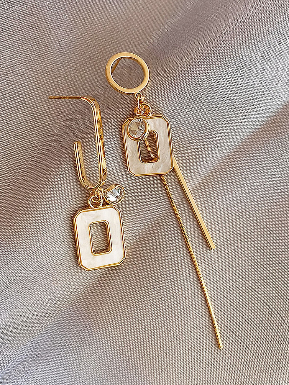 bijzondere asymmetrische oorbellen wit met goud van world's finest close up