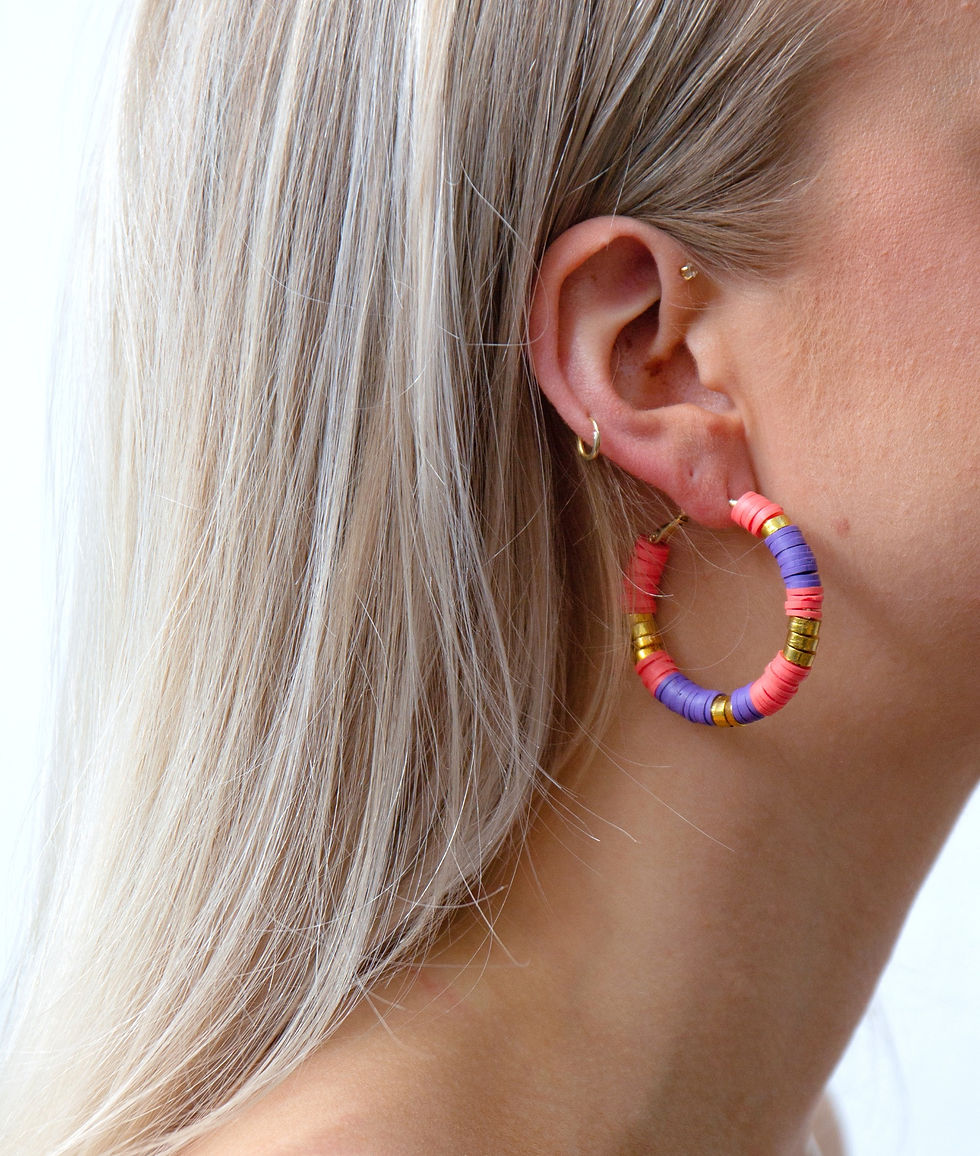 Model draagt opvallende oorringen in vrolijke kleuren.