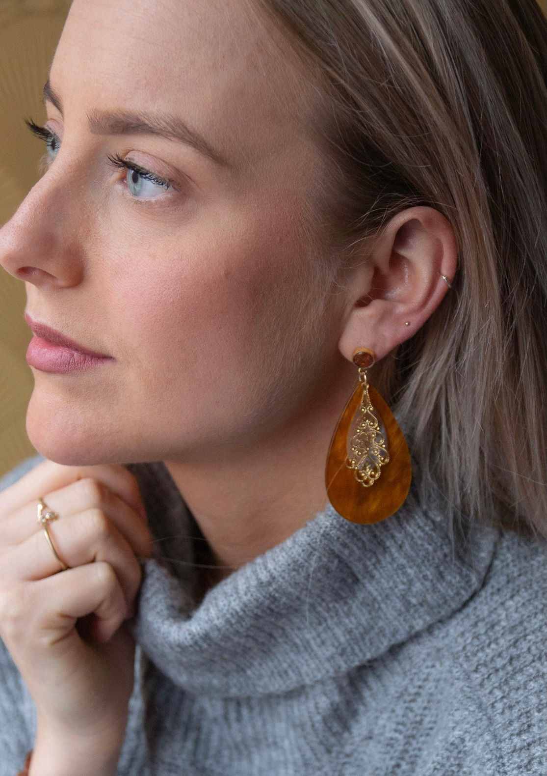 model draagt lange feestelijke oorbellen in bruin met goud van world's finest