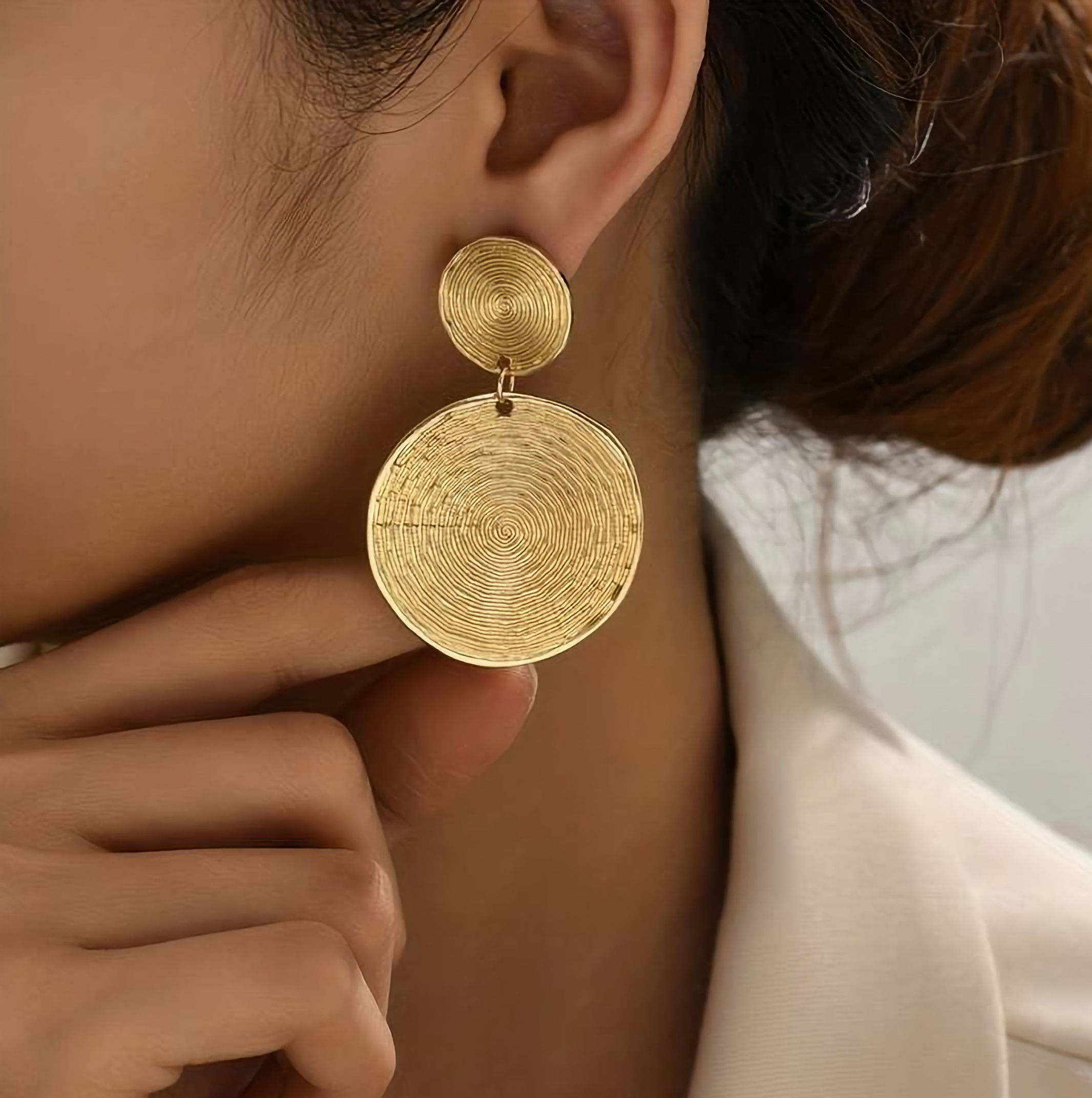 model draagt grote ronde gouden oorbellen van world's finest