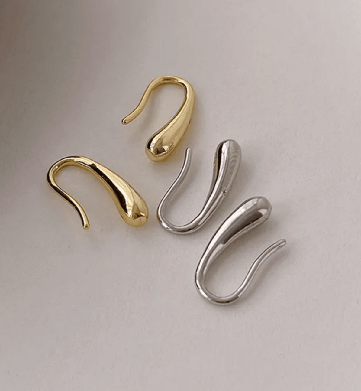 Minimalistische kleine druppel oorbellen in goud en zilver met drop vorm van world's finest bovenaanzicht