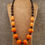 Thumbnail: lange statement  ketting met grote kralen oranje en bruin van world's finest vooraanzicht