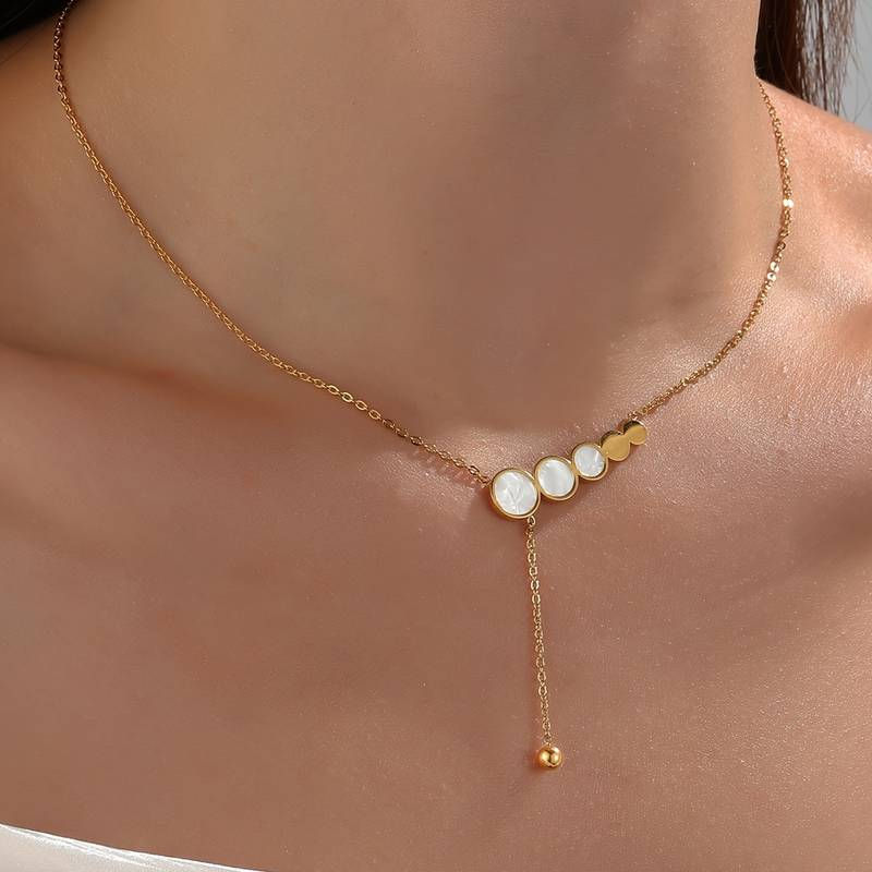 Thumbnail: model draagt dunne ketting in goud met parelmoer bedel