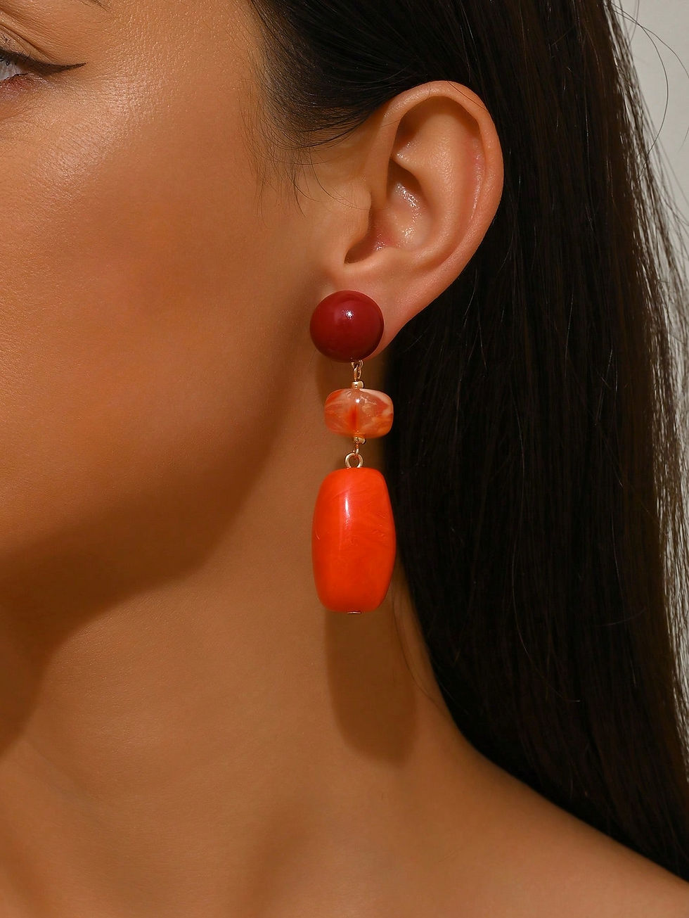 gekleurde statement oorbellen bordeaux met oranje hars van world's finest modelfoto