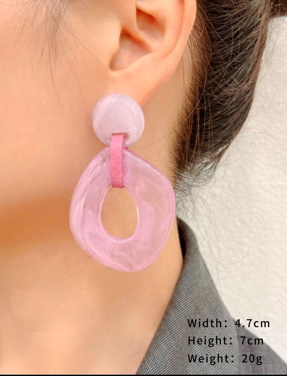 model draagt grote roze gekleurde oorbellen van world's finest