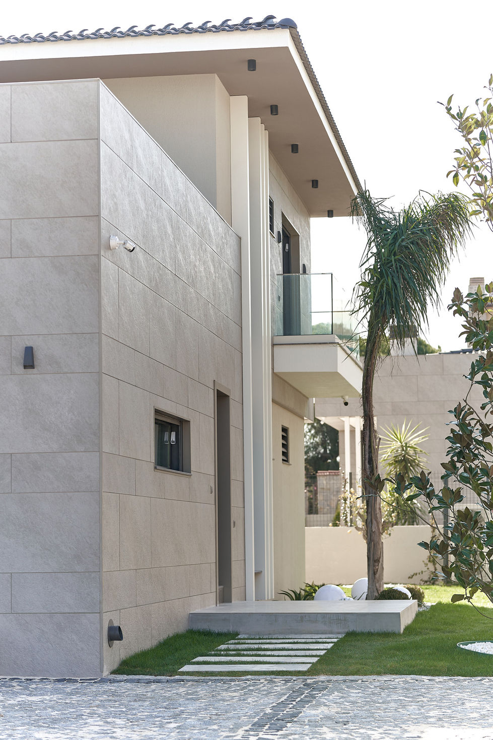 a house with a balcony and a palm tree in front of it