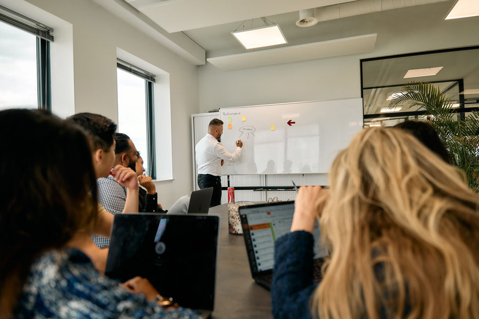 People in a meeting room with a whiteboard.