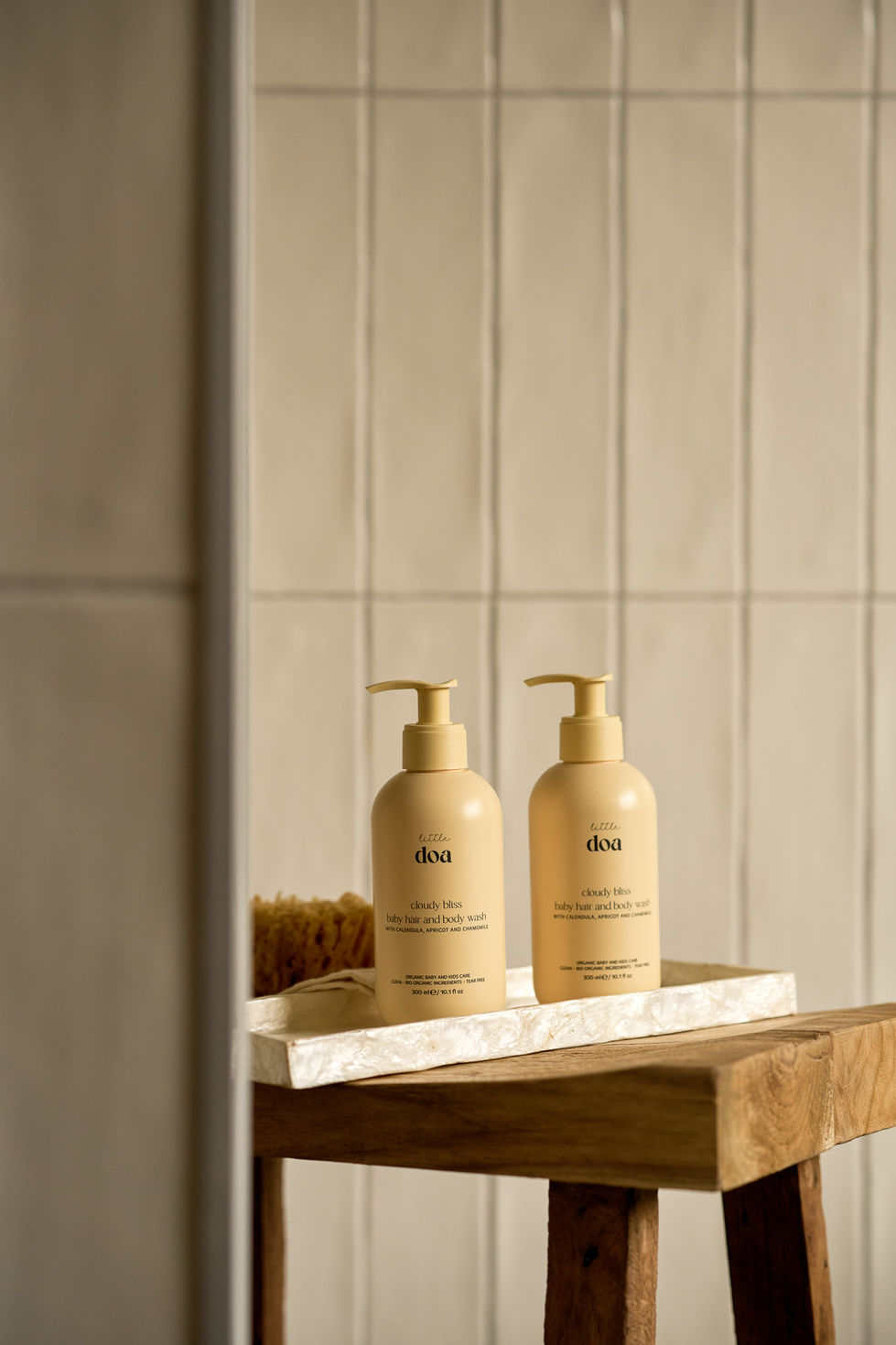 Two lotion bottles on a bathroom shelf.