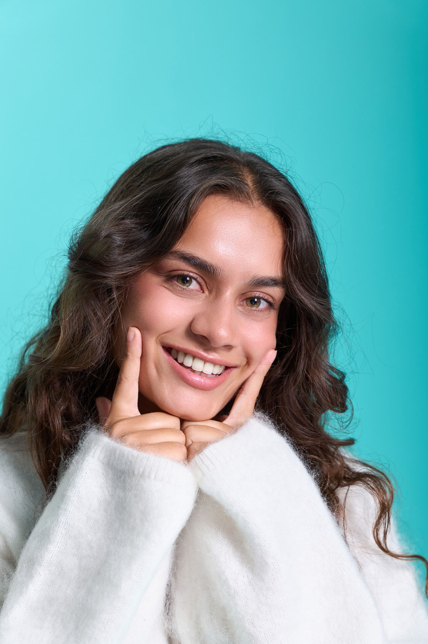 Smiling person posing against a turquoise background.