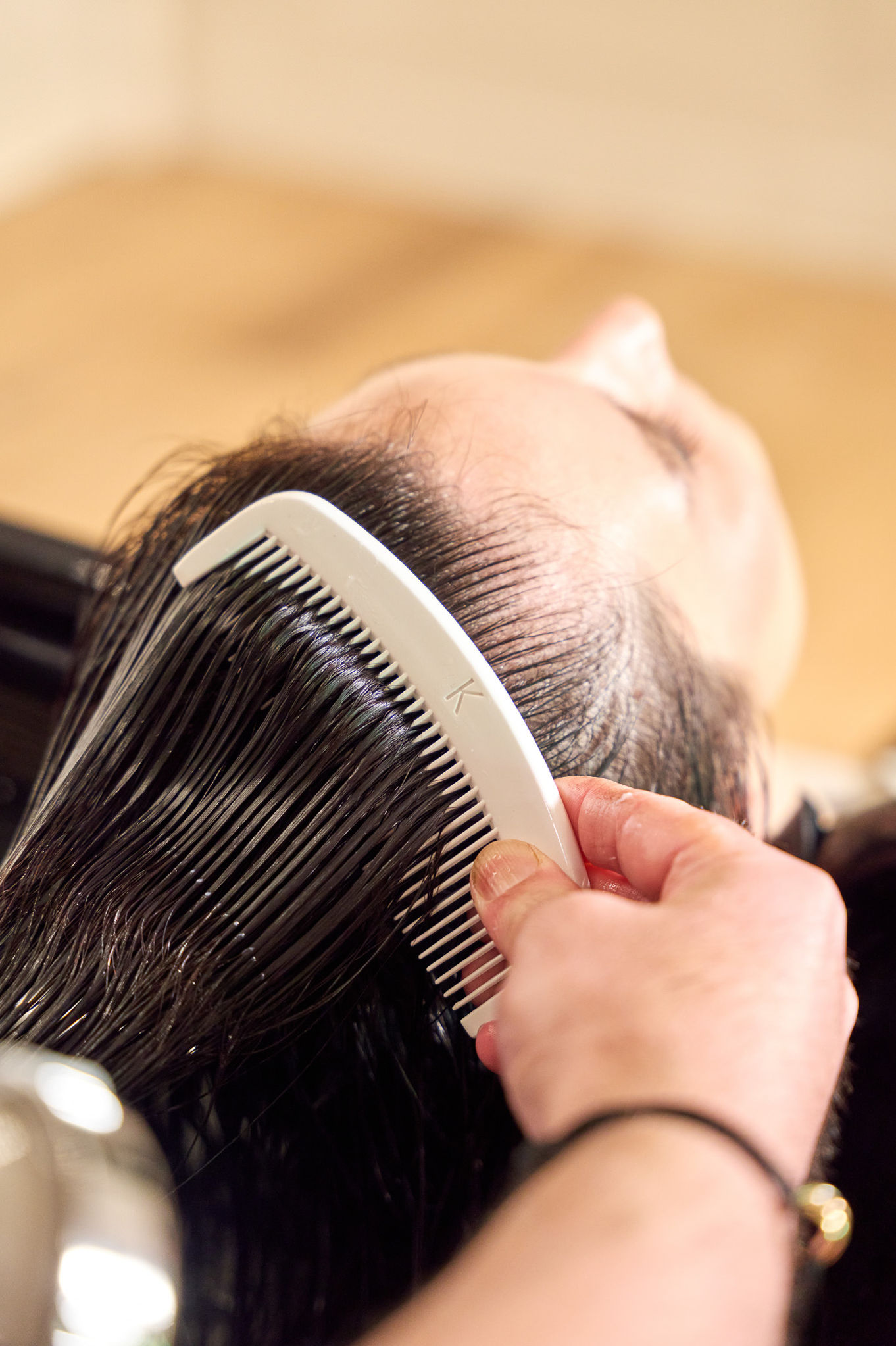 Combing wet hair at a salon.