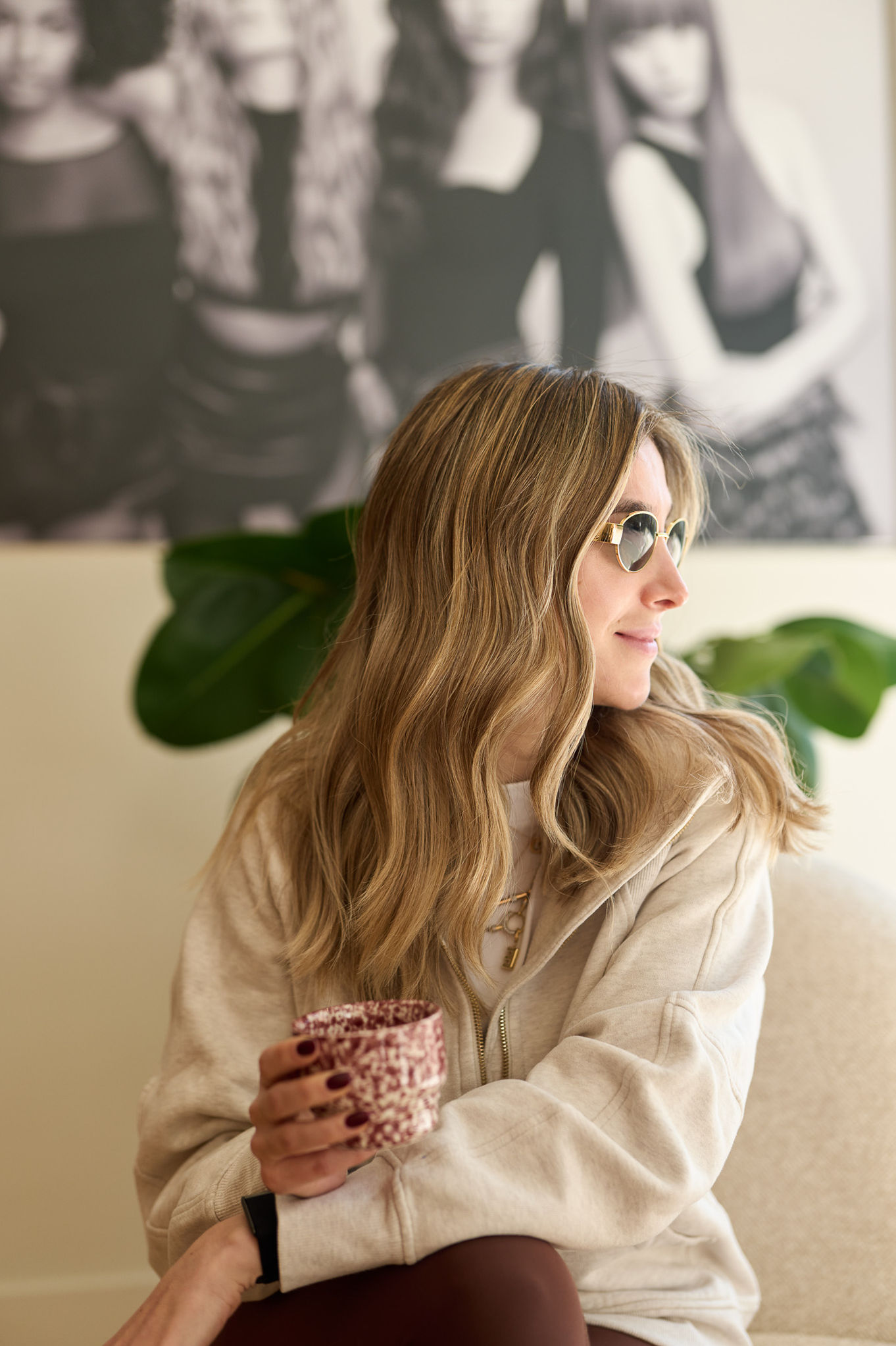 Woman with wavy hair holding a patterned mug.