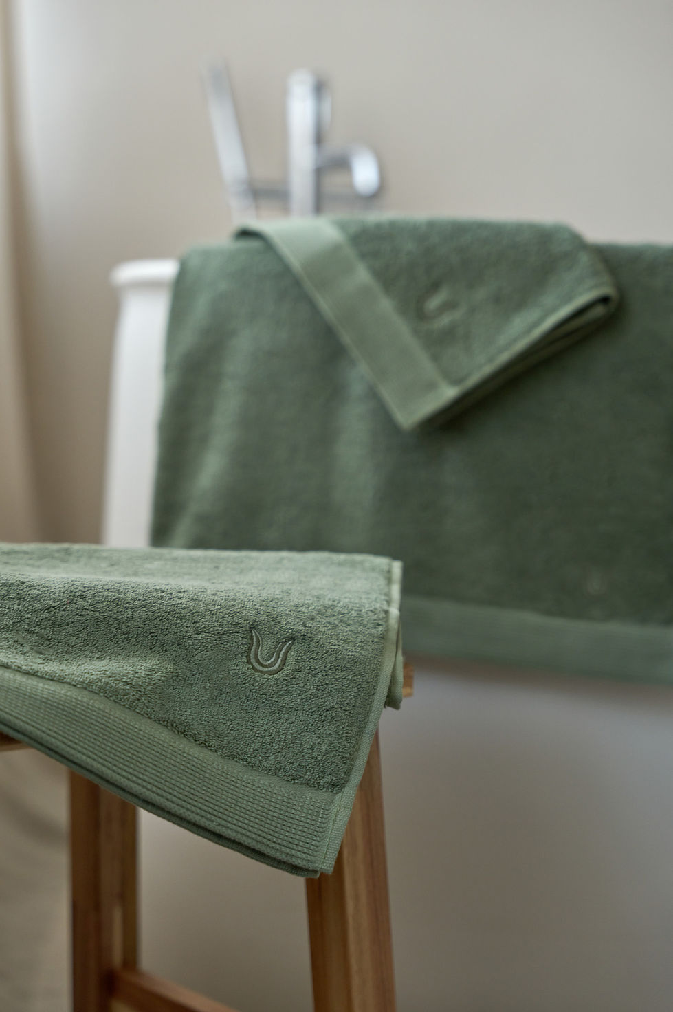 Green towels displayed in a bathroom setting.