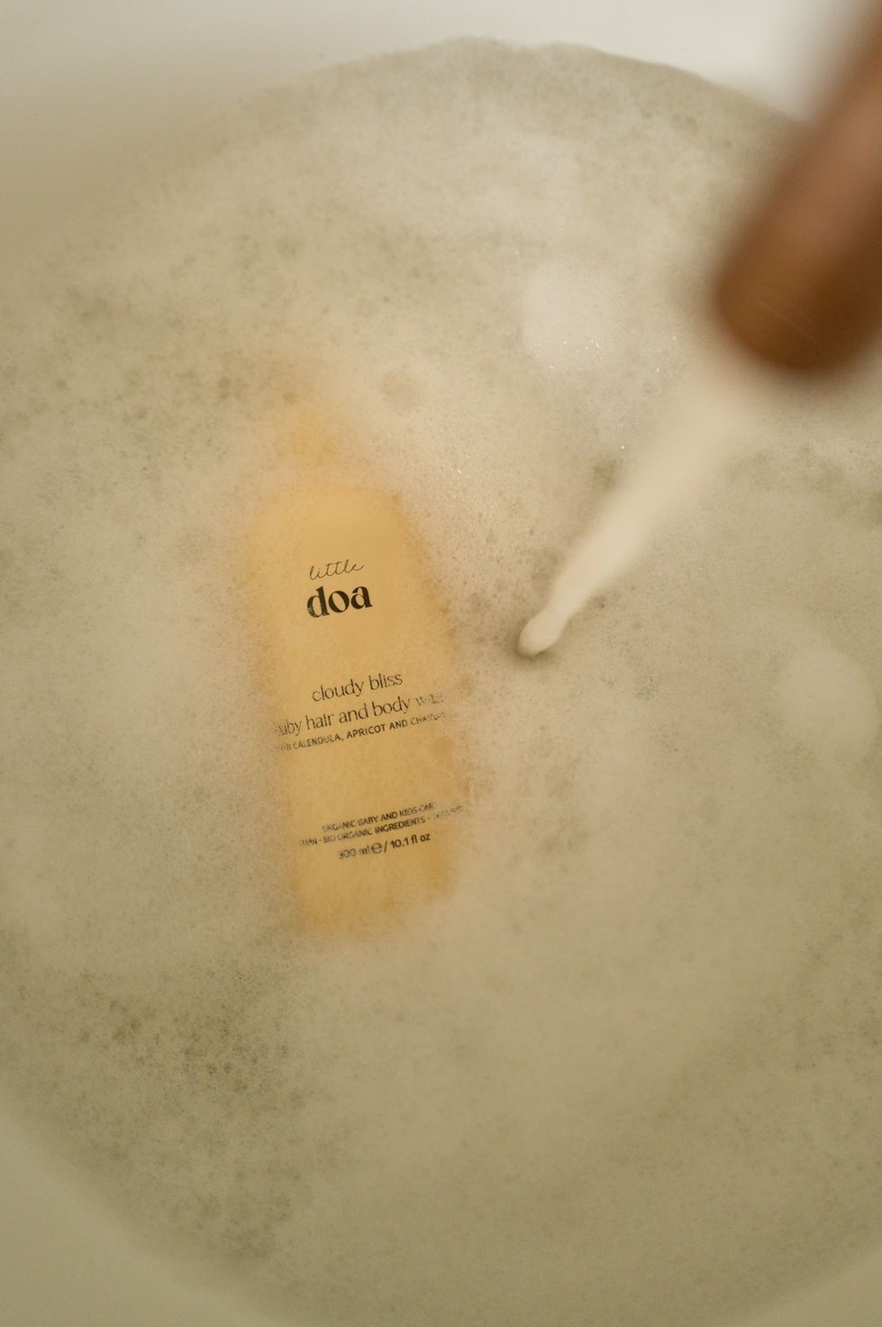 Bottle in a bubble bath with running water.