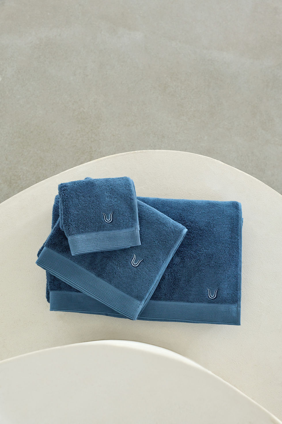Blue towels neatly folded on a white surface.