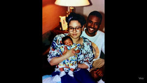 A couple sitting and holding baby