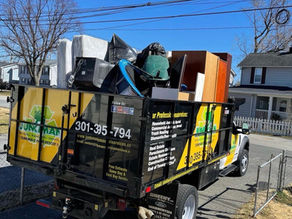 Junkman Removal dump truck loaded with furniture and household junk during a residential cleanout in Maryland.
