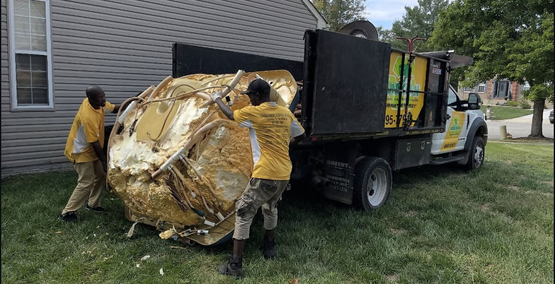 Crew loading a dismantled hot tub shell onto a truck for professional removal and disposal
