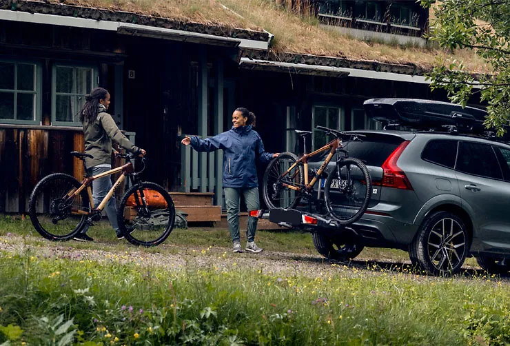 by-a-cottage-two-women-unload-their-bikes-from-a-thule-rear-bike-rack.webp