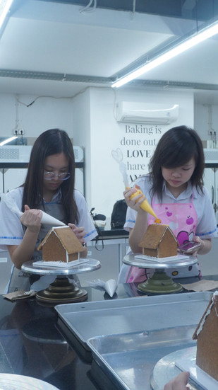 Gloria Senior High School students creating mini gingerbread houses during a culinary workshop at Sages Academy Surabaya ahead of the Christmas season.