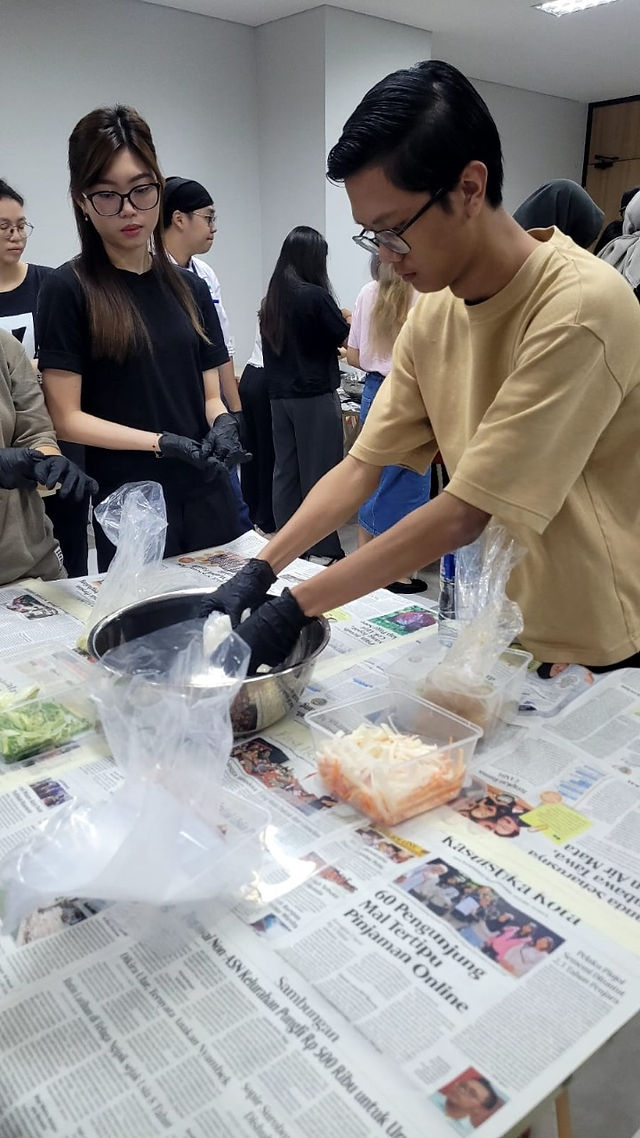 Ciputra University students proudly show their homemade kimchi after a Korean culture class.