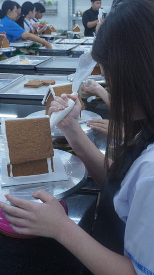 Gloria Senior High School students creating mini gingerbread houses during a culinary workshop at Sages Academy Surabaya ahead of the Christmas season.