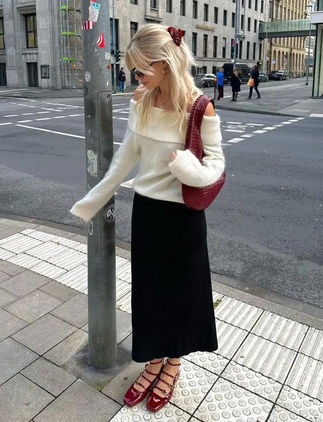 girl on the side walk with red shoes and red shoulder bag