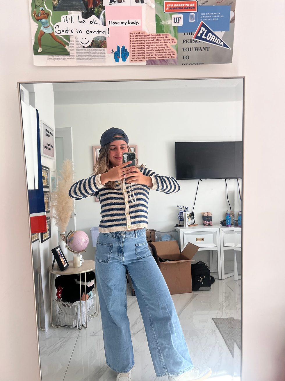 Girl posing with silly pose in front of mirror.