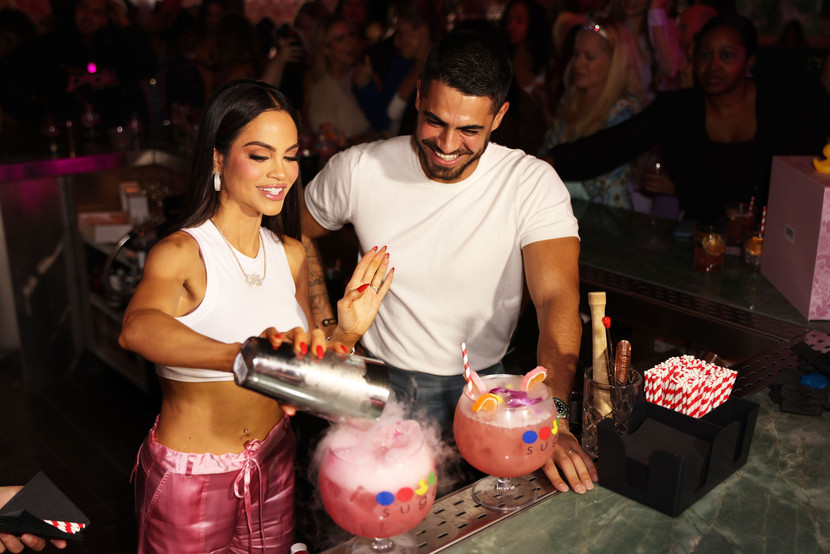 Natti Natasha pouring a drink with bartender 