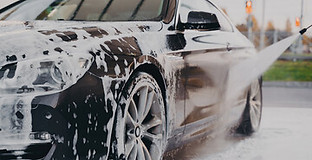 A soapy car being sprayed down