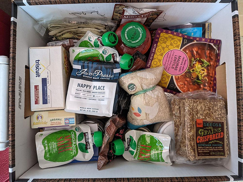 A box filled with food items--crackers, coffee, rice, pasta and more.