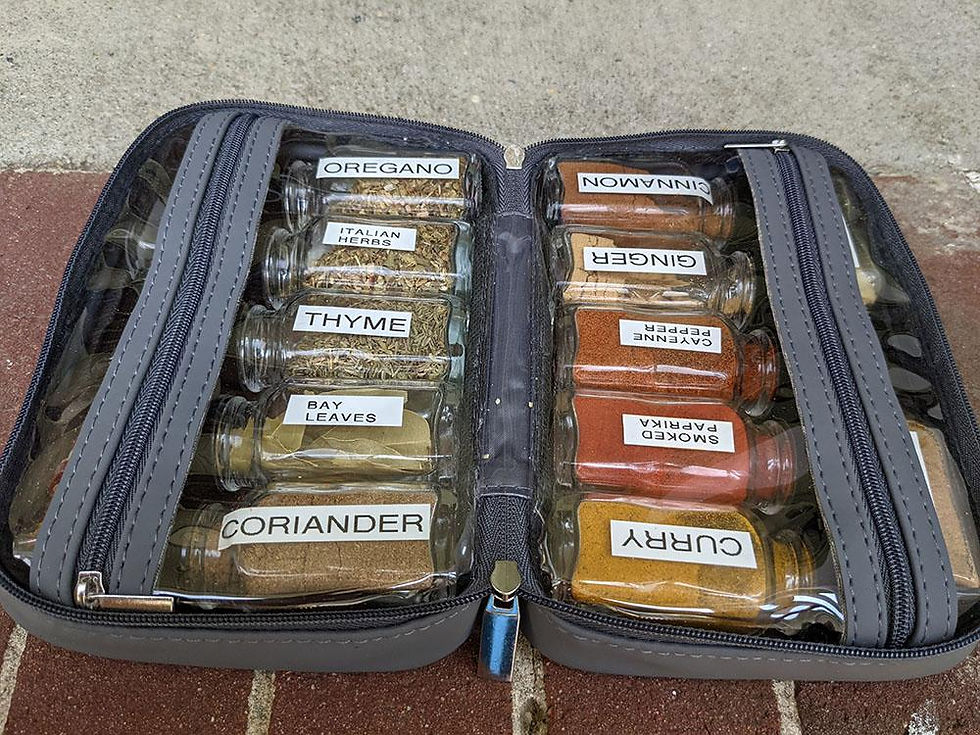 A zipper case holds labeled spice jars like oregano and curry. The case is open on a brick and concrete surface.