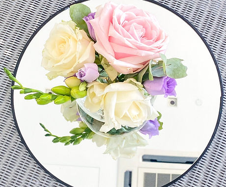 A bistro table centerpiece with a mix of pink and white flowers and a touch of lilac. Suitable for any occasion including birthdays, anniversary, wedding, bridal shower etc.