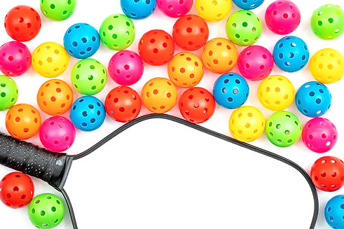 Black and White pickleball paddle with colorful small pickleballs on white background.jpg