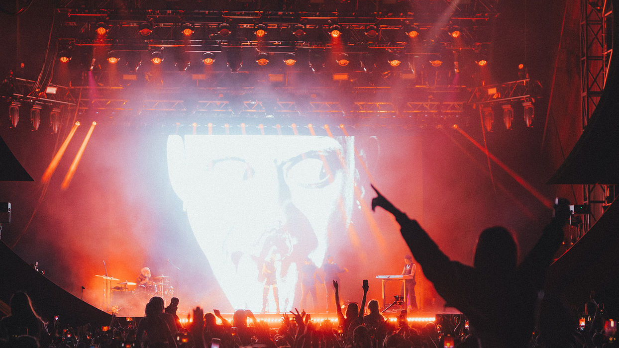 Love Saves stage at night, crowd silhouetted by red light.