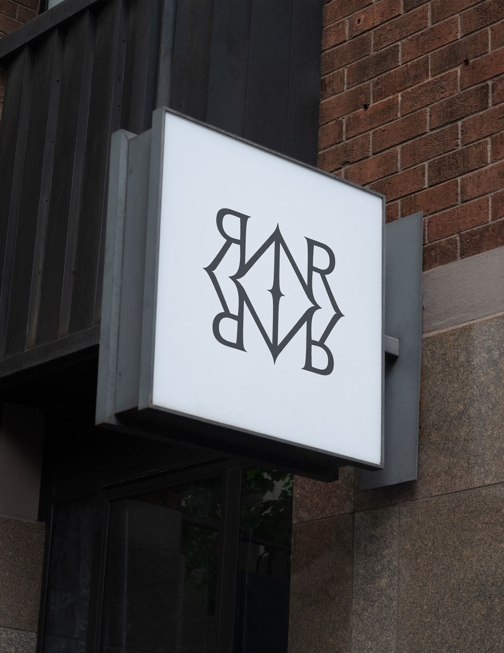 Illuminated exterior signage featuring the No Regrets monogram outside the tattoo studio.
