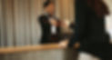 Smiling female concierge returning the documents to hotel guest after check-in process. Fe