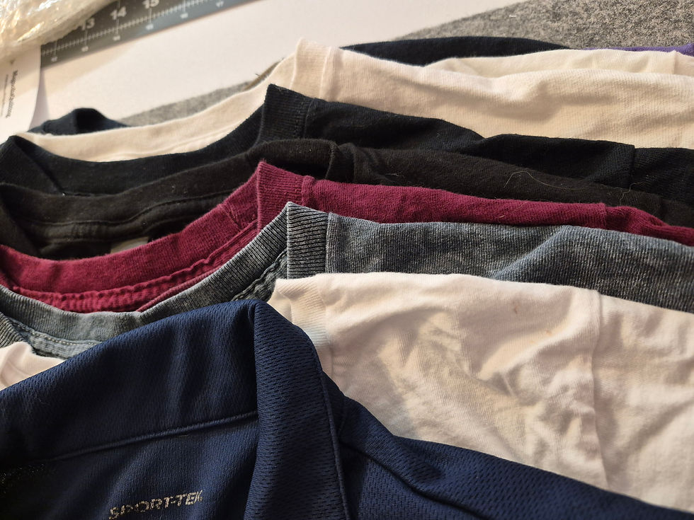 Stack of assorted T-shirts waiting to be transformed into a custom T-shirt memory quilt.