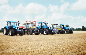 A row of farm equipment parked in a field