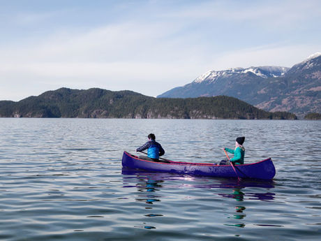 Couple canoeing on calm lake implying the peace attained from understanding each other's neurodivergent behaviors through relationship therapy.