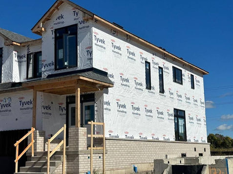 Tyvek HomeWrap installed by GTA Tarping on a new home with a light brick base in the GTA