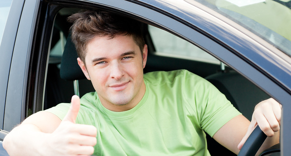 Handsome male driver sitting in a car an