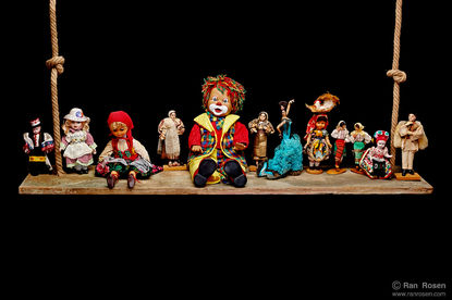 Beautiful dolls on a wooden board, and a clown doll in the center